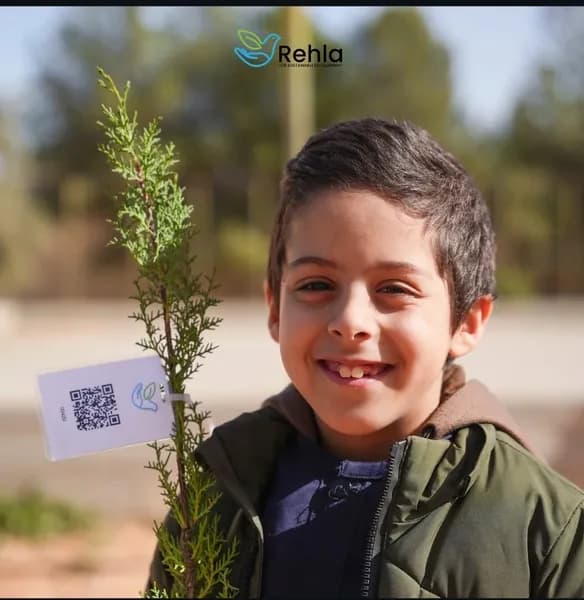 طالب يحمل شتلة غرسة موثقة برمز QR رقم 00420